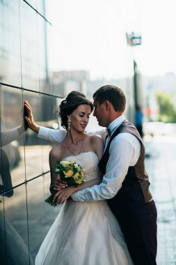 Arkadaki ayna binalarında düğün çifti