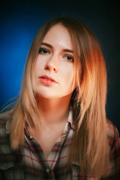 Ritratto sorridente ragazza su sfondo blu in studio — Foto Stock