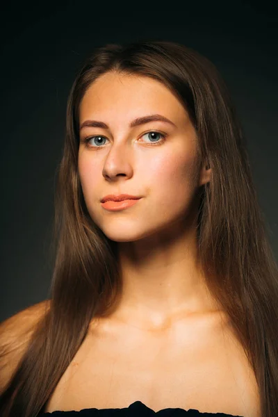 Portret mooi meisje op een donkere studio achtergrond — Stockfoto