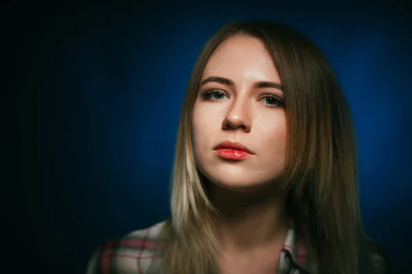 Portret uśmiechnięte dziewczyny na niebieskim tle w studio — Zdjęcie stockowe