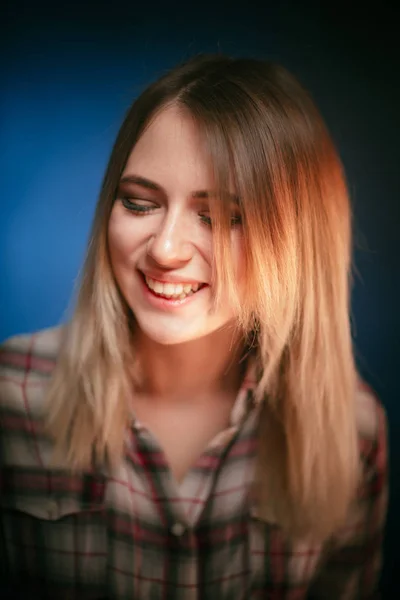 Портрет усміхненої дівчини на синьому фоні в студії — стокове фото