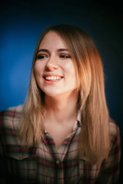 De lachende meisje portret op blauwe achtergrond in de studio — Stockfoto