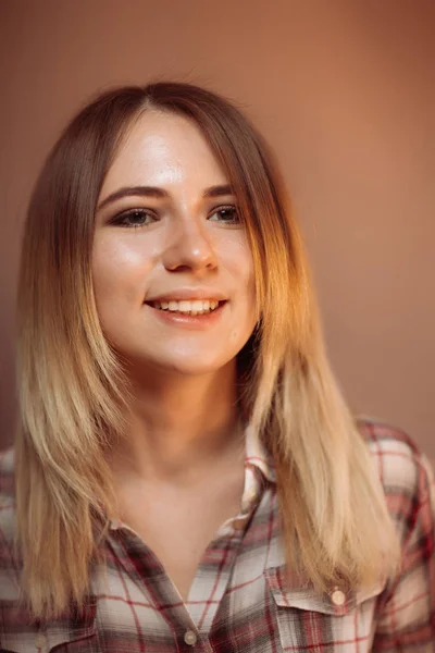 De lachende meisje portret op oranje achtergrond in de studio — Stockfoto