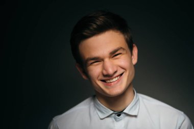 Genç, esmer, beyaz gömlekli adam.