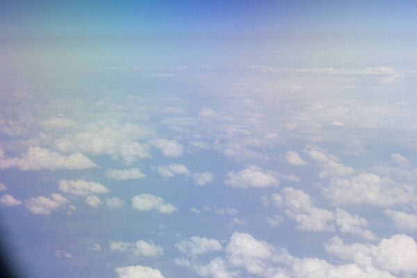 White clouds in the sky are photographed at the height of the flight of the aircraft