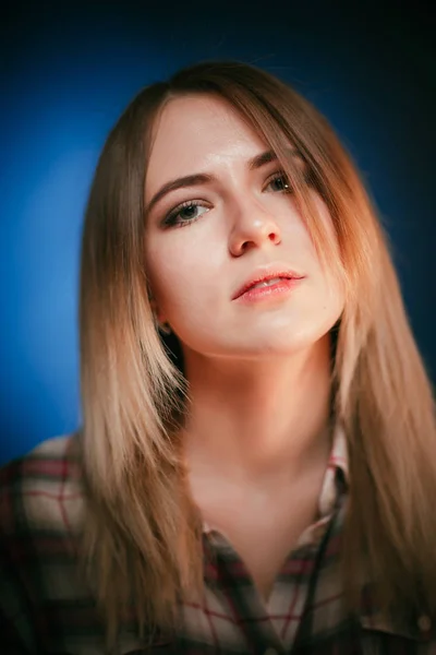 Портрет улыбающейся девушки на синем фоне в студии — стоковое фото