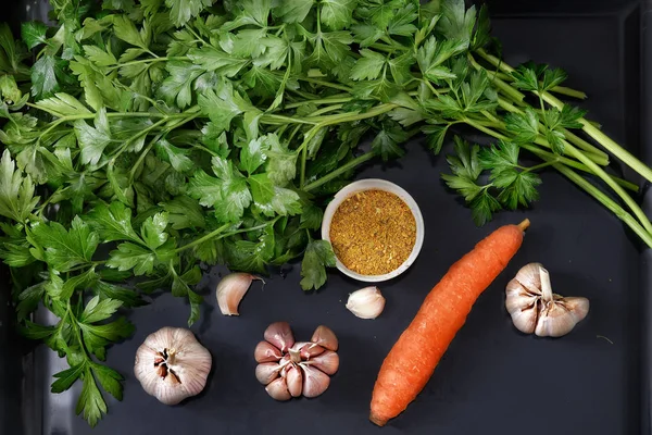 Parsley leaves and vegetables on a dark tray. — Stock Photo, Image