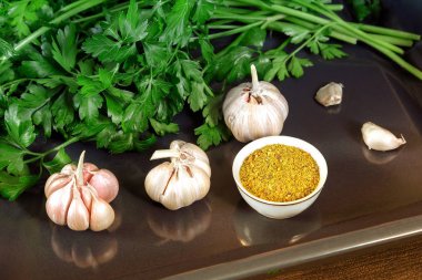 Maydanoz yaprakları ve sarımsak masanın yüzeyi.