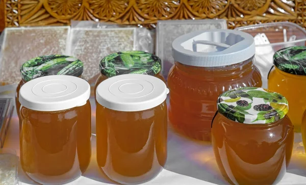 Una variedad de variedades de miel en frascos puestos a la venta en el —  Fotos de Stock