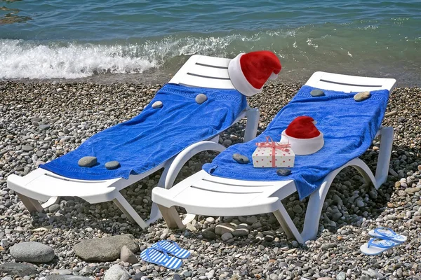 Christmas beach: deckchair and hat of Santa Claus. 3 D visualization. — Stock Photo, Image