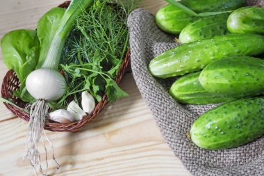 Peçete salatalık, yeşillik ve soğan ile bir hasır sepet yanında duran açayım.