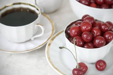 Kahve ve bir fincan masada kiraz.