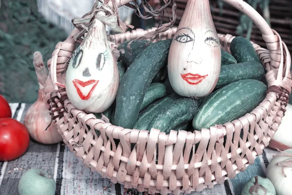 Koszyk z warzywami, duże cebule śmieszne malowane. — Zdjęcie stockowe