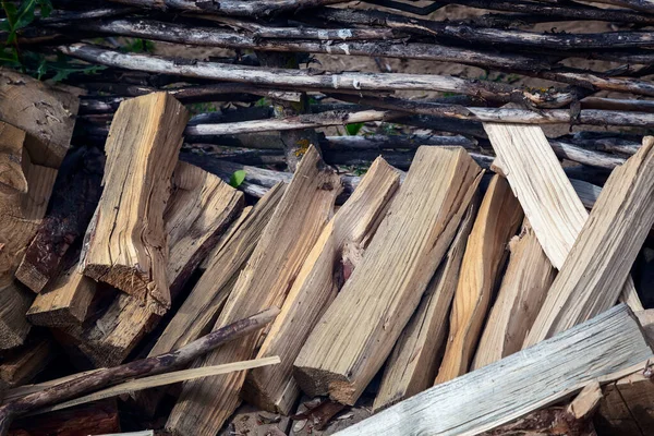 Una pila de madera cerca de una cerca de mimbre — Foto de Stock