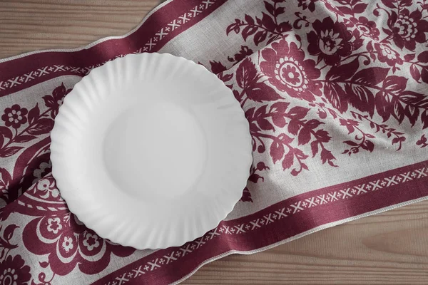 A white empty plate on a linen napkin — Stock Photo, Image