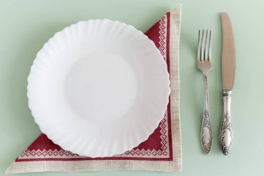 Çarşaf peçetede beyaz boş bir tabak.