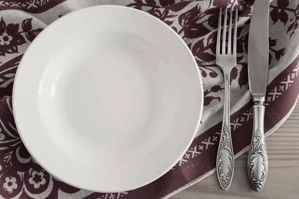 A white empty plate on a linen napkin — Stock Photo, Image