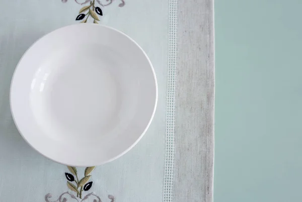 Ένα λευκό άδειο πιάτο σε λινό χαρτοπετσέτα — Φωτογραφία Αρχείου