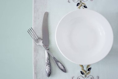 Çarşaf peçetede beyaz boş bir tabak.