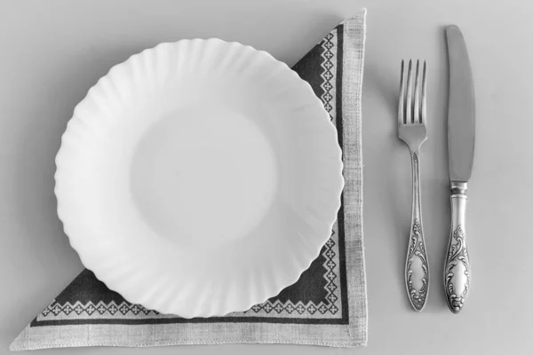 Ein weißer leerer Teller auf einer Leinenserviette — Stockfoto