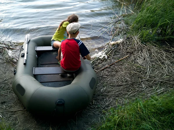 Enfants dans un bateau en caoutchouc sur le lac . — Photo