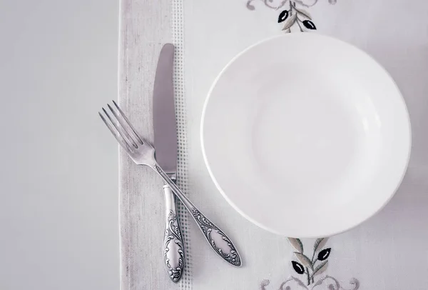 A white empty plate on a linen napkin — Stock Photo, Image