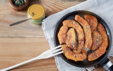 Balkabağı dilimleri, bal ve bitkilerle pişirilmiş.