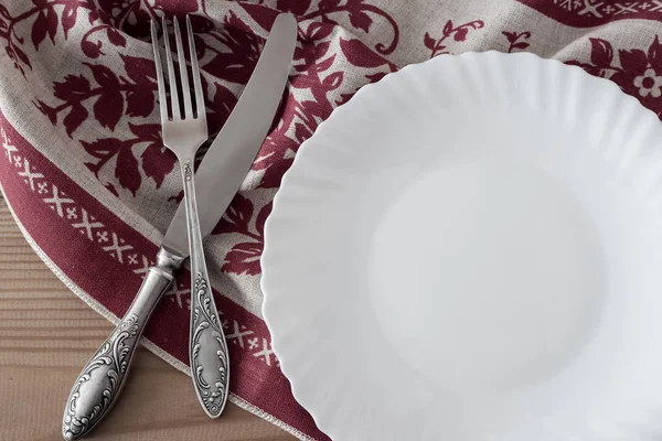 A white empty plate on a linen napkin — Stock Photo, Image