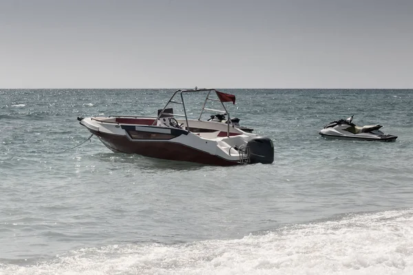 Небольшая лодка и водный скутер у моря . — стоковое фото