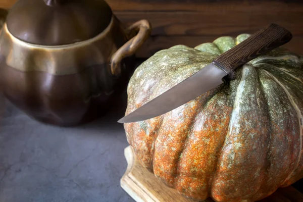 A large pumpkin next to a ceramic pot — Stock Photo, Image