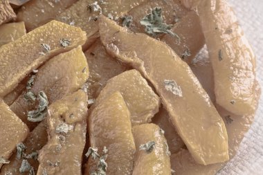 Tahta bir masada, bir peçete tepsisinde, balkabağı dilimleriyle, bal ve otlarla pişirilmiş..