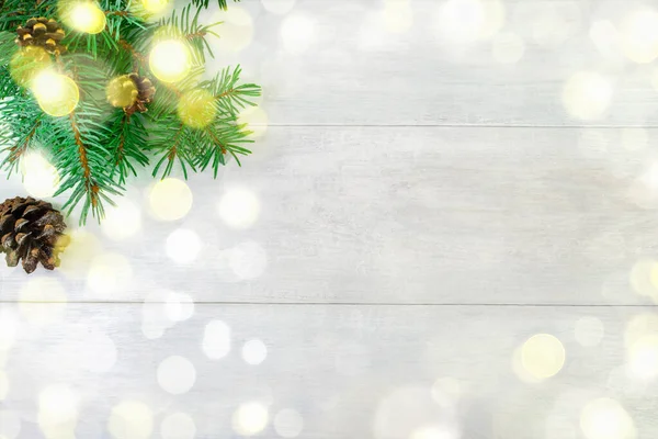 Sol tarafta beyaz ahşap bir zemin üzerinde koni bulunan Noel ağacı dalları. Tebrik kartları ve davetiyeler için yeni yıl konsepti. Boşluğu kopyala.