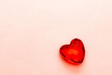 Kırmızı kalp, şeffaf kesilen camdan ya da pembe bir arka planda kesilmiş taştan yapılmış, boşluğu kopyala