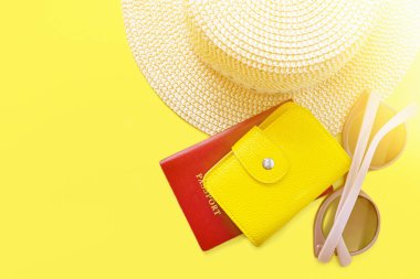 Şapka, güneş gözlüğü ve deri çantalı pasaport. Yaz tatili geçmişi. Yaz zamanı, seyahat, plaj, turizm konsepti. Kopyalama alanı olan güneşli sarı arkaplan.