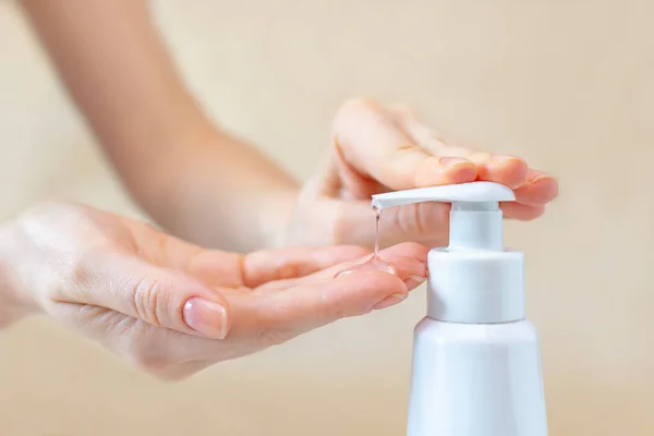 A female press on a bottle with antibacterial gel to clean and wash hands of bacteria and virus close-up. The concept of protection and prophylaxis against coronavirus disease.