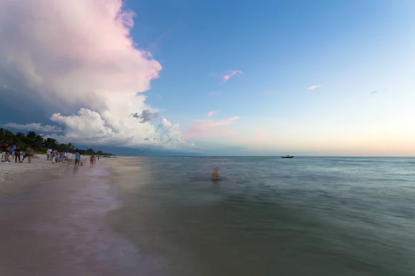 Naples beach and calm ocean during a lightning storm at sunset, Florida, USA. Amazing cloudscape during a big tropical storm in the Gulf of Mexico, close to Everglades National Park.Amazing lightning storm sunset and calmed ocean, at Naples beach, Fl