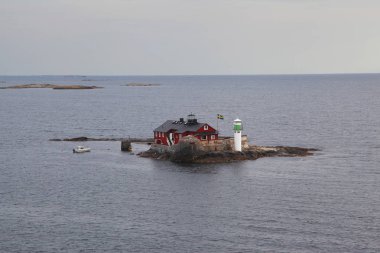 A lone lighthouse in the Swedish skerries clipart