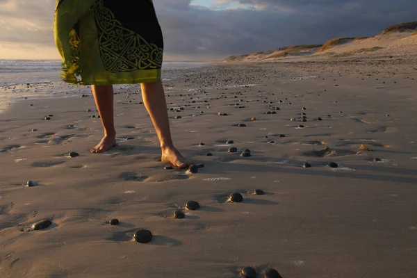 Beine eines Mädchens bei Sonnenuntergang am Strand der Atlantikküste — Stockfoto