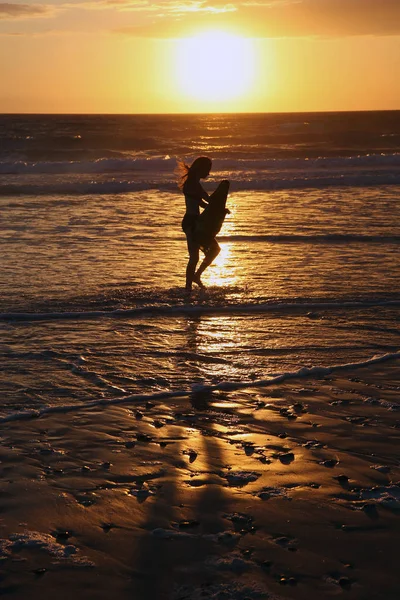 Silhuetten av en flicka i solnedgången på stranden i Atlantkusten — Stockfoto