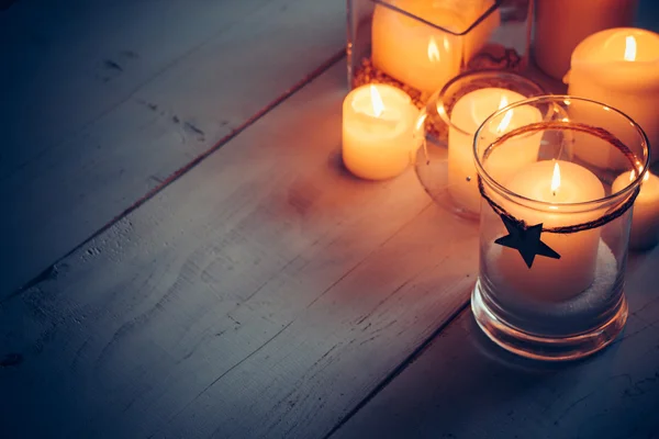 Рождественские свечи на белом деревянном фоне — стоковое фото