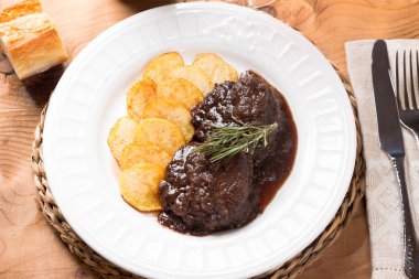 Demlenmiş Domuz eti yanakları kırmızı şarap ve patates kızartması ile