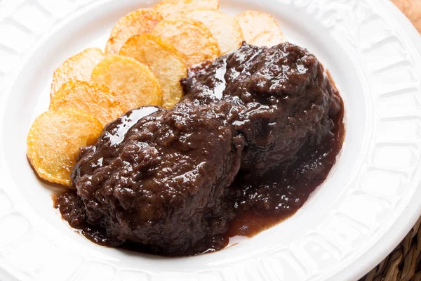 Pork cheeks  stewed with red wine and chips