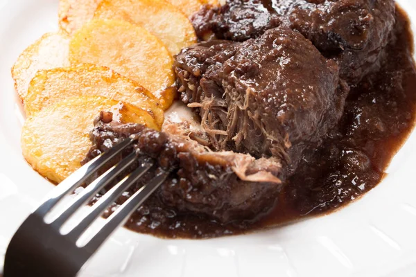 Pork cheeks  stewed with red wine and chips