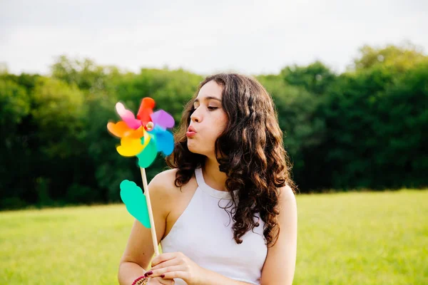 Mladá žena fouká větrný mlýn — Stock fotografie