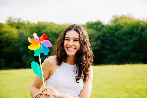 Happy woman holding a windmill toy — Stock Photo, Image