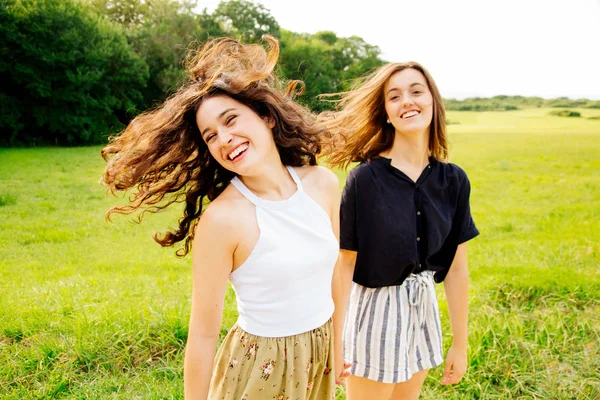 Laughing female friends moving hair — Stock Photo, Image