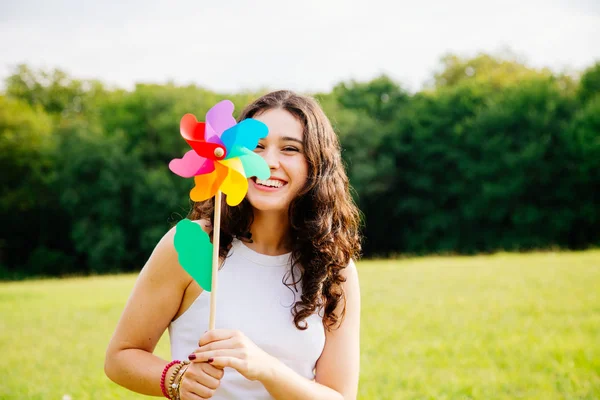 Funny young woman holding a windmill — Stock Photo, Image