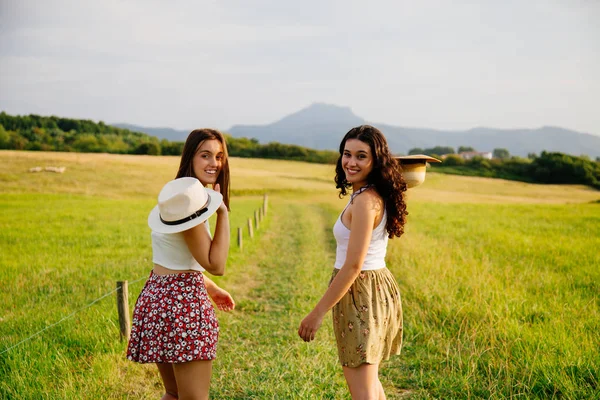 Girls walking in a green meadow — Stock Photo, Image