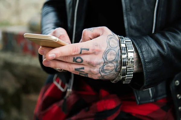 Tatuerade mannen händerna med smartphone — Stockfoto