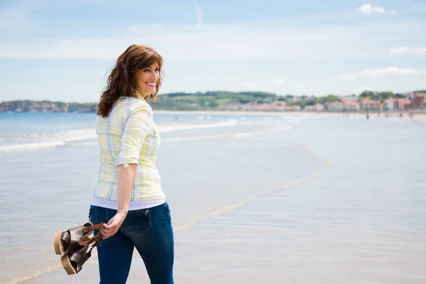 Donna felice a piedi lungo la riva del mare — Foto Stock